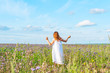 © klavdiyav - girl in a field of buckwheat. girl in white dress from back. girl in the harvest field