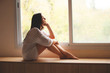 © Andriy Petrenko - woman sitting on the window sill
