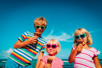 happy kids- boy and girls- eating ice cream on beach