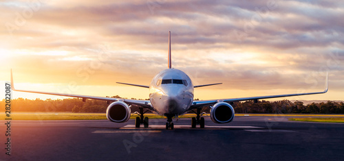 Fotografiet  Sunset view of airplane on airport runway under dramatic sky in Hobart,Tasmania, Australia