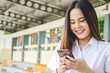 © TeTe Song - Portrait of thai adult student university uniform beautiful girl is enjoying social media on her smartphone.