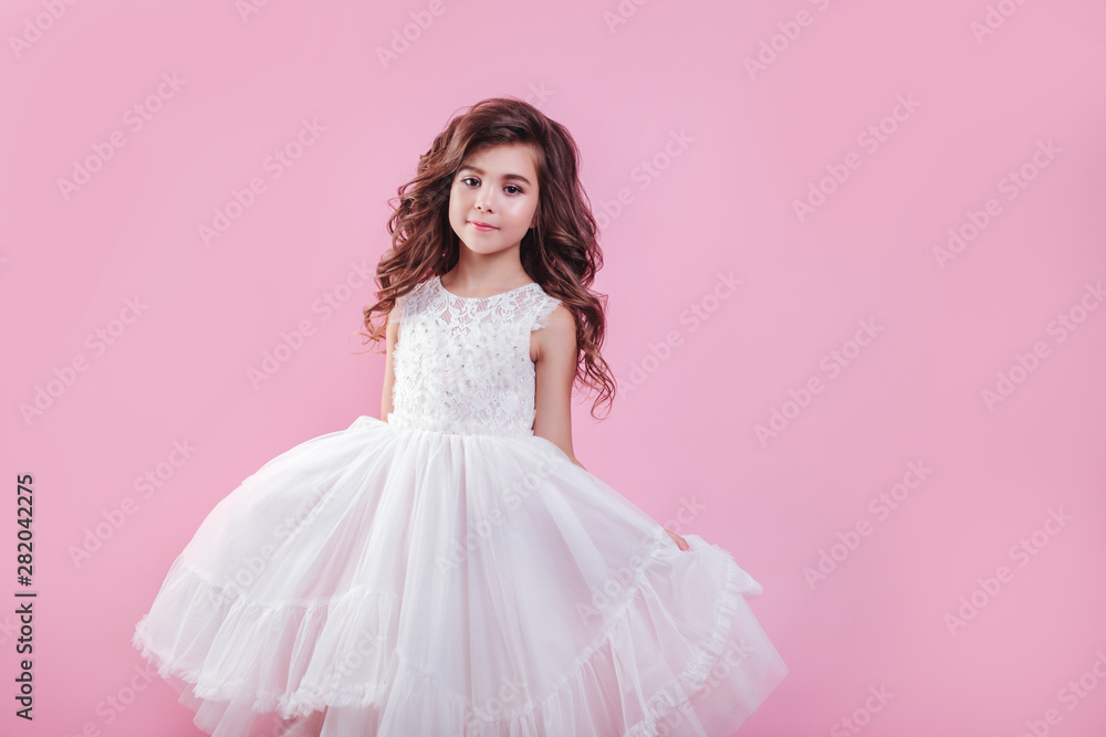 portrait of beautiful little girl in white dress on pink background ...
