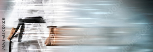 Ταπετσαρία τοιχογραφία Guy poses in white kimono with black belt on motion background