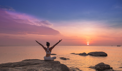 Asian girl practice Yoga on the beach Sunrise morning day