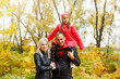 © Angelov - Happy family walking on the rural dirt road. Little girl sitting on dad's shoulder
