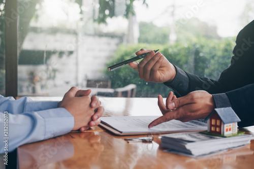 Fotografía real estate agent holding house key to his client after signing contract,concept