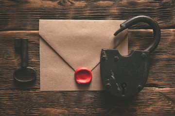 Wall Mural - top secret documents in envelope, rusty padlock and a key on a wooden table flat lay background. con