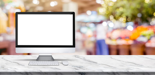 Wall Mural - blank screen desktop computer on marble table top with blur people shopping at supermarket bokeh bac
