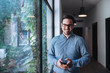 © bnenin - Smile of confident businessman standing close to window.