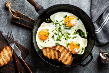 fried eggs in a cast iron pan top view