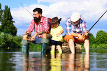 Boy With Father And Grandfather Fly Fishing Outdoor Over River Background. Young - Adult Concept. Old And Young. Little Boy On A Lake With His Father And Grandfather.