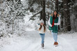 © alexkich - Young family for a walk. Mom and daughter are walking in a winter park.