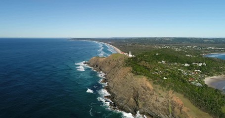 Sticker - Steep cliffs of elevated headland in Byron Bay with famous white stone lighthouse on the top navigating in Pacific ocean from the most eastern point of Australian mainland.