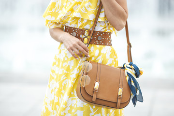 Summer accessories. Women`s accessories. Lady in yellow dress. Handbag with kerchief and sunglasses.