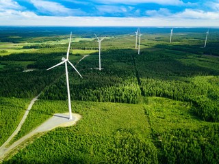 Wall Mural - Aerial view of windmills in summer forest in Finland. Wind turbines for electric power with clean and Renewable Energy