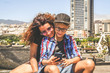 © Fabio Principe - Mother and son watching smartphone together sitting outside in the city. Woman and trendy young boy playing with cell phone. Family video call during summer holiday New technology social media concept