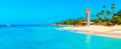 Panoramic view of the tropical beach with lighthouse in Dominican Republic. Coconut Palm trees on white sandy beach.