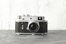 The Old Rangefinder Film Camera With On Grey Cement Background.
