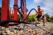 © zamuruev - Athletic looking man working out with rope at street gym yard. Strength and motivation. Outdoor workout.