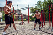 © zamuruev - Athletic man working out with rope in front of brick wall. Strength and motivation. Outdoor workout.