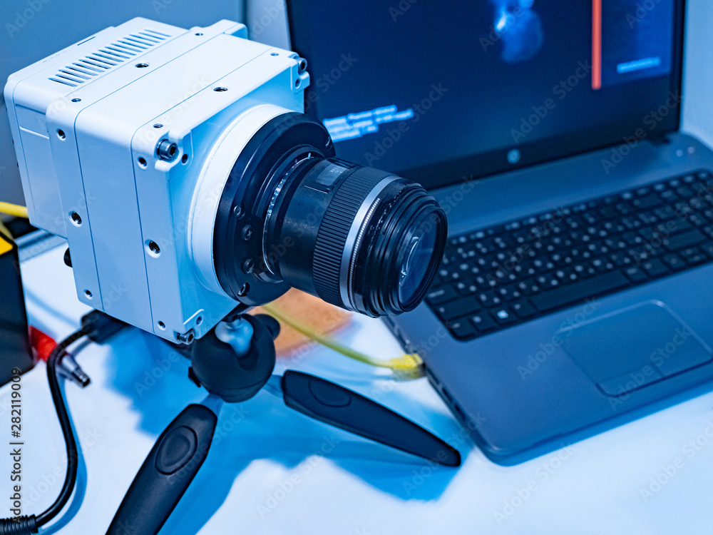 Machine Engineering Camera The camera on the tripod and the computer on the desktop of the ...