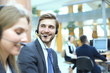 © ty - Portrait of call center worker accompanied by his team. Smiling customer support operator at work.