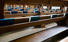 Selective Focus View Of Many Wooden Church Pews With Blue Bibles