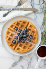 Wall Mural - Belgian Waffle with Blueberries and Maple Syrup, Dusted with Powdered Sugar, Flay Lay on Marble Background, Copy Space