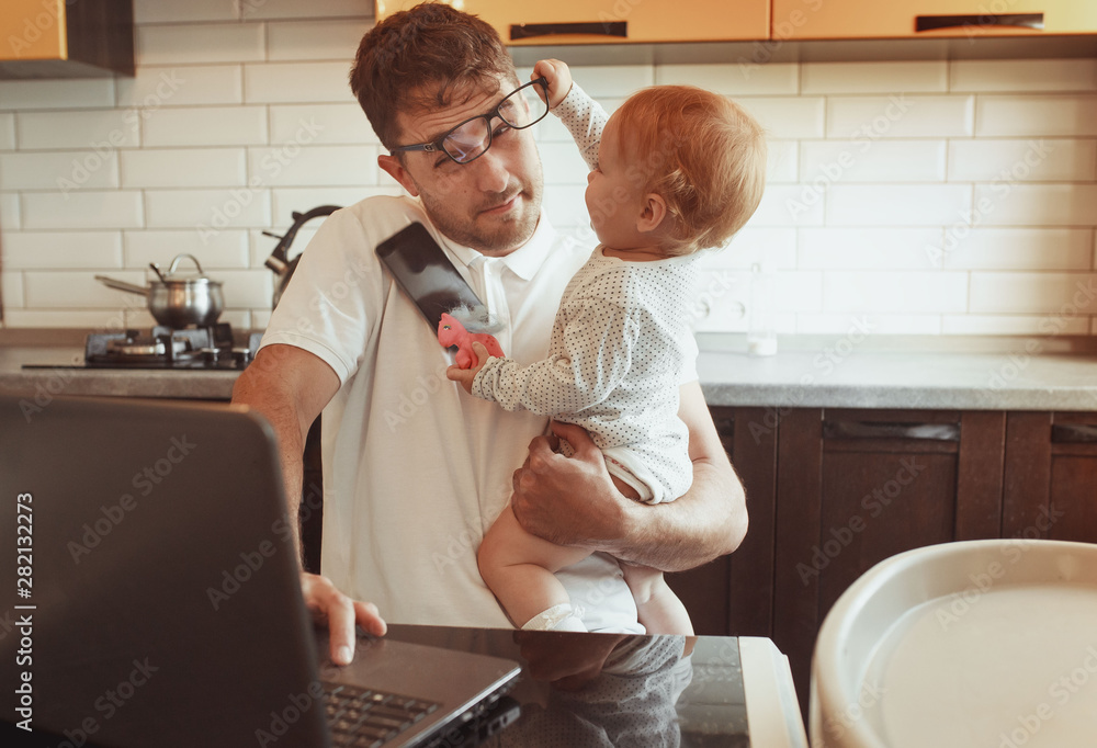 Multitasking Father Working From Home On Laptop With Baby daughter - obrazy, fototapety, plakaty 