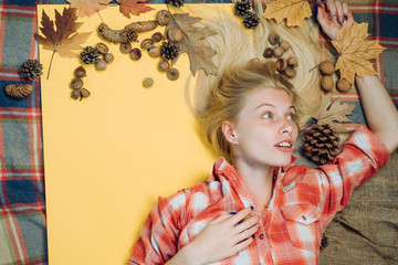 Wall Mural - Girl wearing in autumn clothes on autumn sunny day. Attractive young woman in a seasonal clothes whith golden leaf. Fashion girls. Leaf fall. Beautiful sensual blonde playing with leaves.