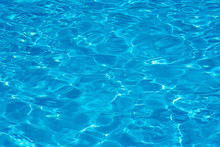 Background Of Water In A Blue Swimming Pool, Water Surface With Sun Reflection