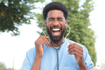 Beautiful happy doctor outside in the park