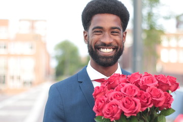 Wall Mural - Beautiful happy man outside in the park with roses