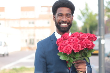 Wall Mural - Beautiful happy man outside in the park with roses