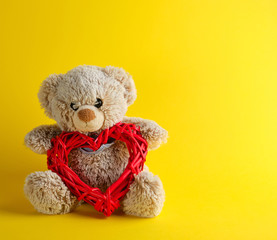 brown teddy bear sitting on a yellow background