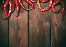 Ripe Red Chili Peppers On A Brown Wooden Vintage Background