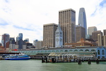 Clock Tower Of Ferry Building And Financial Center Downtown In San Francisco