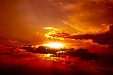 Beautiful red sunset above the clouds with rays of light