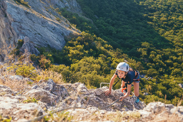 Kid girl climbing mountain. 