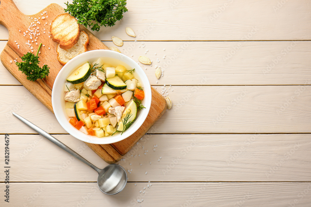 Bowl of tasty soup on wooden table