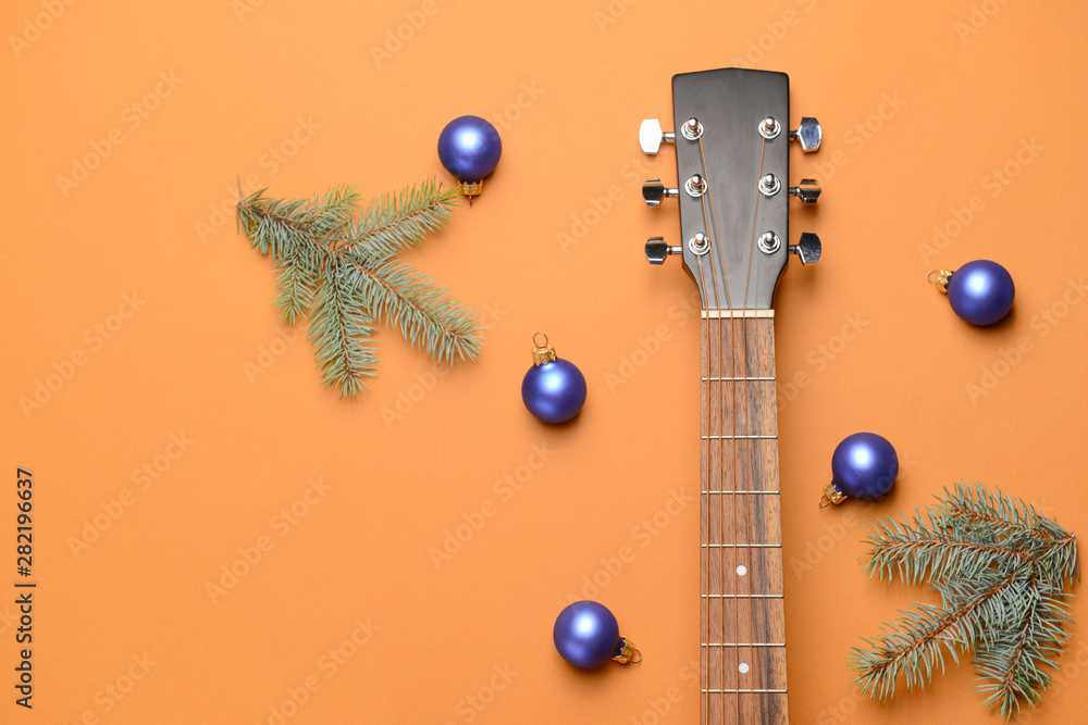 Guitar and Christmas decor on color background
