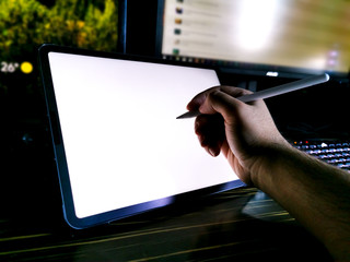 male hand drawing illustration on pro tablet next to gaming workstation pc