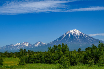 Panoramic view of the city Petropavlovsk-Kamchatsky and volcanoes: Koryaksky Volcano, Avacha Volcano, Kozelsky Volcano. Russian Far East, Kamchatka Peninsula.