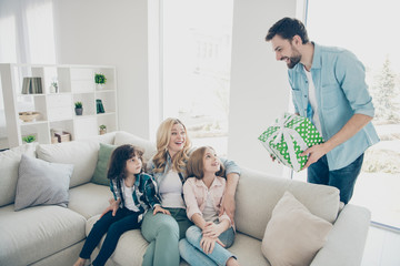 Young foster family daddy giving giftbox two children unexpected morning congratulations