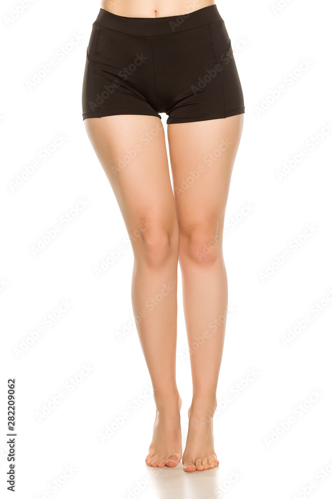 Young woman waxed long naked legs standing on her toes. Isolated on