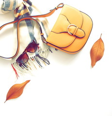 Autumn composition with women fashion  accessories top view on white background toned. Flat lay collage of female style look with bag, sunglasses, scarf, notebook mock up, autumn leaves. Copy space