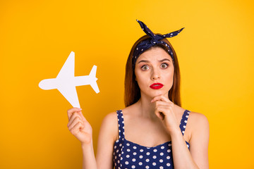 Sticker - Close-up portrait of her she nice attractive puzzled confused straight-haired girl holding in hands white plane decide decision one way isolated over bright vivid shine yellow background