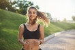 © Liubov Levytska - Healthy and active lifestyle, sport concept. Attractive ecstatic young sportswoman, athletic female wear black sportsbra, fitness tracker, smiling joyfully as jogging, sprinter run in park