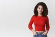 © Cookie Studio - Stylish attractive confident sassy young girl modern photographer hold hands pockets wearing red cropped top smiling cheeky self-assured listen coworker during project studio, white background
