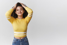 Attractive Carefree Relaxed Modern Young Mixed-race Curly-haired Girlfriend Wearing Stylish Cropped Top Touch Hair Hold Hands Head Loose Standing Joyful Smiling Pleased Enjoy Perfect Party